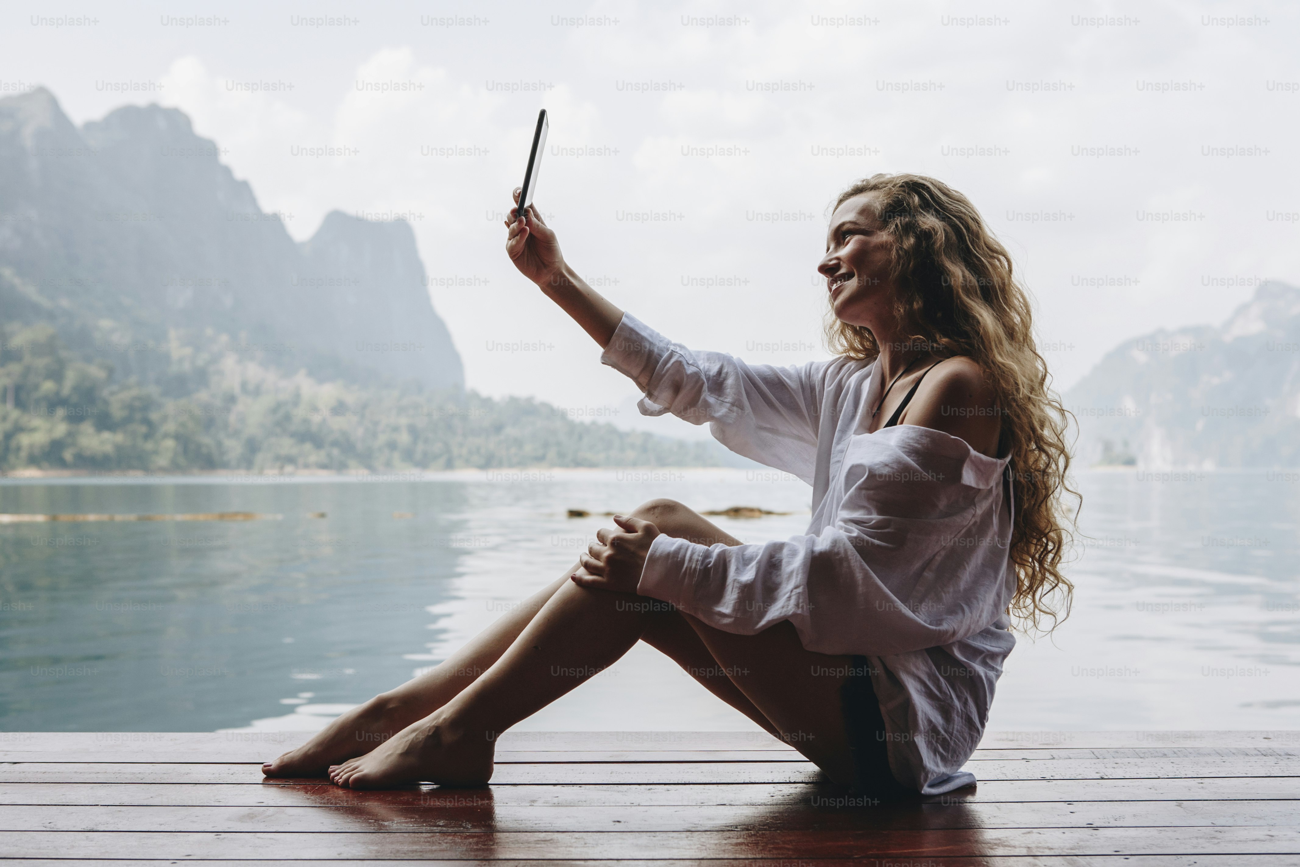 Woman using her phone by a lake
